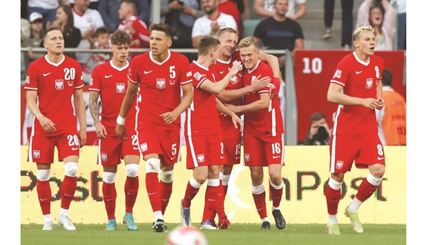 Polandu2019s Jakub Kaminski (right) celebrates with teammates after scoring their first goal against Wales during their Nations League Group D match in Wroclaw, Poland, yesterday. (Reuters)