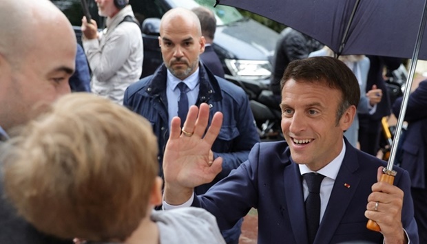 French President Emmanuel Macron greets supporters as he leaves after voting in the second round of French parliamentary elections, at a polling station in Le Touquet-Paris-Plage, France. REUTERS