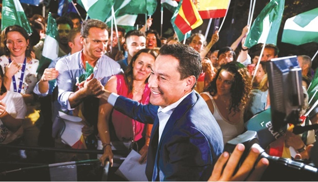 Andalusian Regional President and Peopleu2019s Party candidate Juan Manuel Moreno Bonilla greets supporters as he celebrates the result in Andalusian regional elections at the party headquarters in Seville. (Reuters)