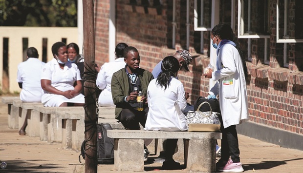 Zimbabwean medical workers sit outside Sally Mugabe Hospital during a strike by state doctors and nurses to press for higher pay, in Harare, yesterday.