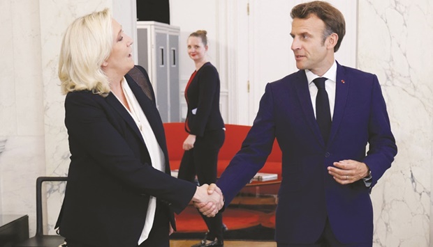 Far-right Rassemblement National leader and Member of Parliament Marine Le Pen (left) shakes hands with President Emmanuel Macron after talks at the presidential Elysee Palace in Paris yesterday. (AFP)