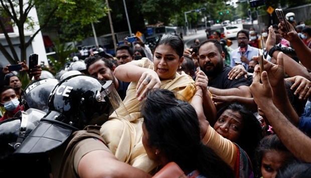 Hirunika Premachandra, a politician and a leader of Samagi Vanitha Balawegaya, a part of the main opposition party Samagi Jana Balawegaya, tries to jump over the barriers while pushed by supporters, during a protest near Sri Lanka's Prime Minister Ranil Wickremesinghe's private residence, amid the country's economic crisis, in Colombo, Sri Lanka. REUTERS