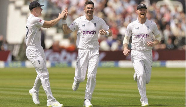 Englandu2019s James Anderson  (centre) celebrates with Matthew Potts (left) and Ben Stokes after taking the wicket of New Zealandu2019s Will Young during the first day of the first Test at Lordu2019s. (Reuters)