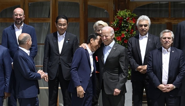 US President Joe Biden (C-R) hugs Indonesia's President Joko Widodo (C-L) as they pose for a family photo with G7-leaders and participants of the outreach program at Elmau Castle, southern Germany, where the German Chancellor hosts a summit of the Group of Seven rich nations (G7)