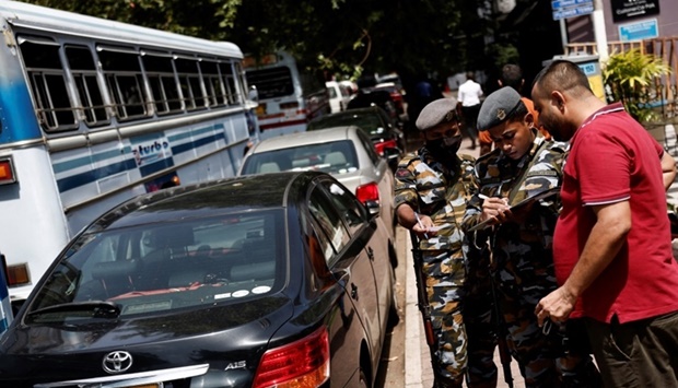 Sri Lanka's Air Force members distribute tokens to people queueing for fuel due to fuel shortage, amid the country's economic crisis, in Colombo, Sri Lanka. REUTERS