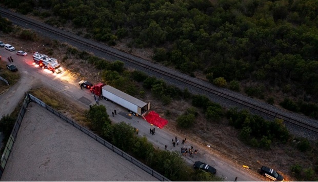In this aerial view, members of law enforcement investigate a tractor trailer on June 27, 2022 in San Antonio, Texas. According to reports, at least 46 people, who are believed migrant workers from Mexico, were found dead in an abandoned tractor trailer.