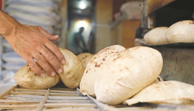 A baker collects bread at a bakery in Cairo. Some 71.5mn Egyptians rely on bread subsidies, which account for 57% of the stateu2019s subsidy budget, according to official figures.