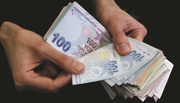 A merchant counts Turkish lira banknotes at the Grand Bazaar in Istanbul (file). Consumer prices rose an annual 73.5%, up from 70% in April, according to data released by the state statistics agency on Friday. The median forecast in a Bloomberg survey of 20 economists was 74.7%.