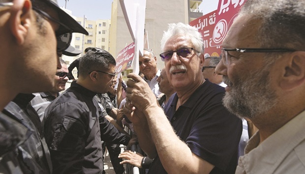 Tunisian labour party spokesman Hamma Hammami (centre) is among demonstrators blocked by the police as they headed toward the headquarters of the electoral authority ISIE, during a rally against their president, in the capital Tunis, yesterday.