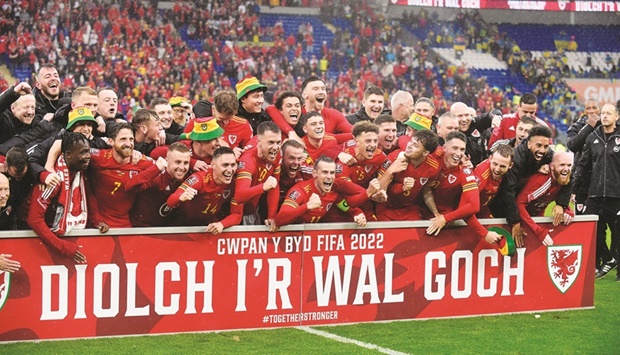 Wales players celebrate after qualifying for the Qatar FIFA World Cup following their win over Ukraine in Cardiff yesterday. (Reuters)