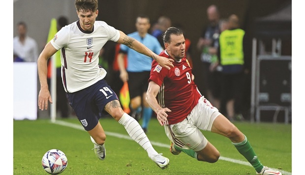 Englandu2019s defender John Stones (left) and Hungaryu2019s forward Adam Szalai vie for the ball during their UEFA Nations League match at the Puskas Arena in Budapest, Hungary, on Saturday. (AFP)