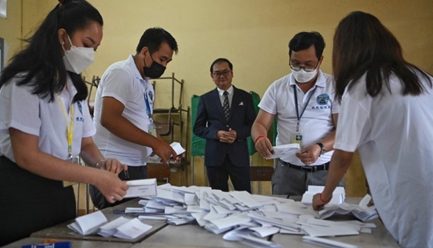 Cambodian election officials count ballots as Sovannarom Dim (C), a member of the National Election Committee and chief of quick reaction information team of NEC, observes at a polling station during local commune elections in Phnom Penh on June 5, 2022
