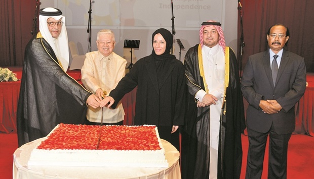 Philippines ambassador Alan L Timbayan is joined by Qatar's Minister of Education HE Buthaina bint Ali Al Jabr al-Nuaimi, HE the Minister of Communications and IT Mohammed bin Ali bin Mohammed al-Mannai in cutting a ceremonial cake at the diplomatic reception as Qatar Ministry of Foreign Affairs' Department of Protocol director Ibrahim Fakhro and Diplomatic Corps dean and Eritrean ambassador Ali Ibrahim Ahmed look on. PICTURES: Shaji Kayamkulam.