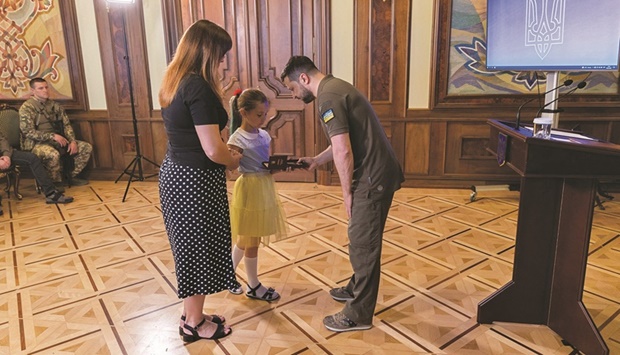 Ukrainian President Volodymyr Zelensky presenting state awards to family members of a media worker who died during Russian invasion of Ukraine yesterday. (AFP)