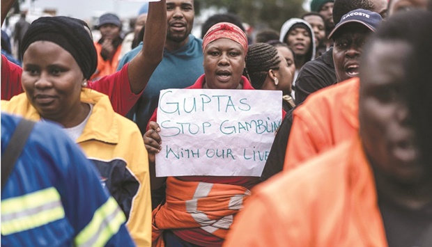 In this file photo taken on February 22, 2018, employees and contractors of the Optimum Coal Mine in Hendrina, owned by the controversial Gupta family, demonstrate with a placard reading u2018Guptas - stop gambling with our livesu2019 in front of the gates of the mine in Hendrina, South Africa. (AFP)