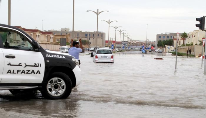 A policeman guiding motorists on a flooded street in Doha's Al Waab area. PICTURE: Thomas Bonnie James.