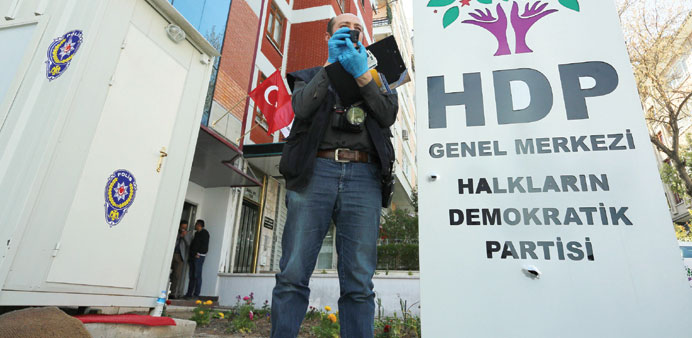  A police officer takes photos after shots were fired at the pro-Kurdish Peoplesu2019 Democratic Party (HDP) headquarters early yesterday morning in Ankar