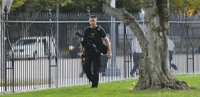A White House guard patrols the perimeter fence on the White House North Lawn along Pennsylvania Avenue in Washington days after the breach in Septemb