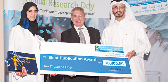 Dr al-Khater presenting a cheque to one of the award winner at the HMC Second Annual Research Day event yesterday.