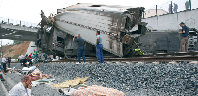 A picture taken on Wednesday shows an injured man sitting next to the body of a victim covered with a blanket following the train accident.
