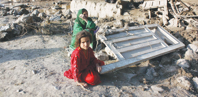 Afghans affected by floods wait for relief, in the Sarobi district of Kabul yesterday.