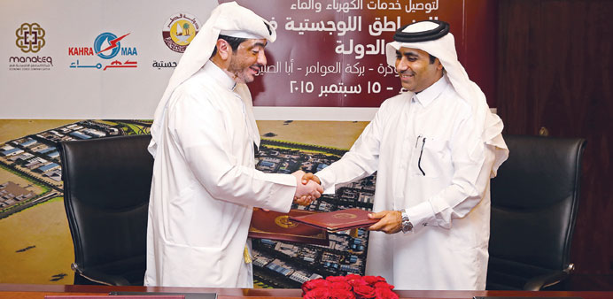 Essa bin Hilal al-Kuwari and Fahad Rashid al-Kaabi shaking hands after signing the deal.