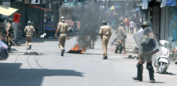 Policemen chase protesters during a demo against the killing of six people yesterday.