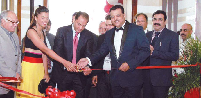 Mugdha Godse and Azharuddin cutting a ribbon to open the hotel as Imran Baig, general manager, and other guests look on.