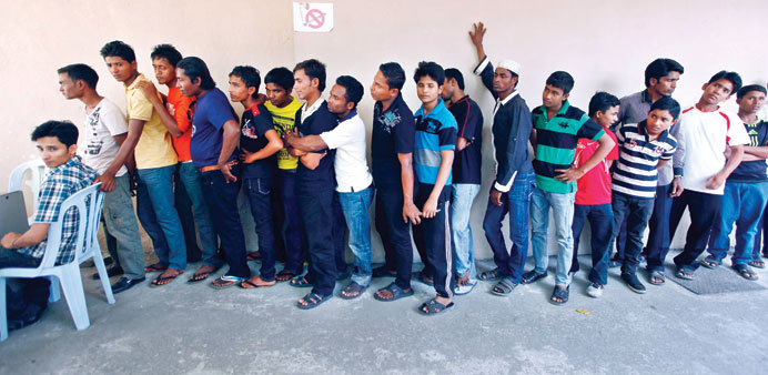 Rohingya men stand in a line at a centre to register for a temporary card issued by the United Nations High Commissioner for Refugees (UNHCR) in Kuala