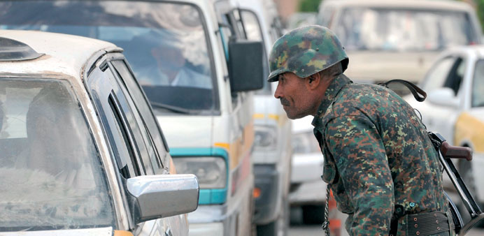A Yemeni soldier searching vehicles at a checkpoint on a road leading to the US embassy in Sanaa yesterday.