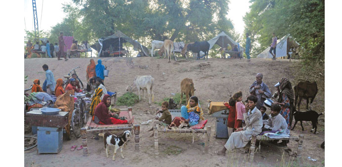 Villagers affected by floods taking shelter on higher grounds on the outskirts area of Multan in Punjab province yesterday.