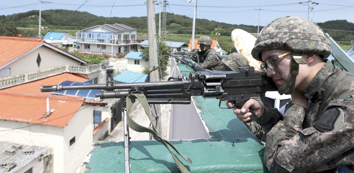 South Korean soldiers take their positions during a search and arrest operation in Goseong.