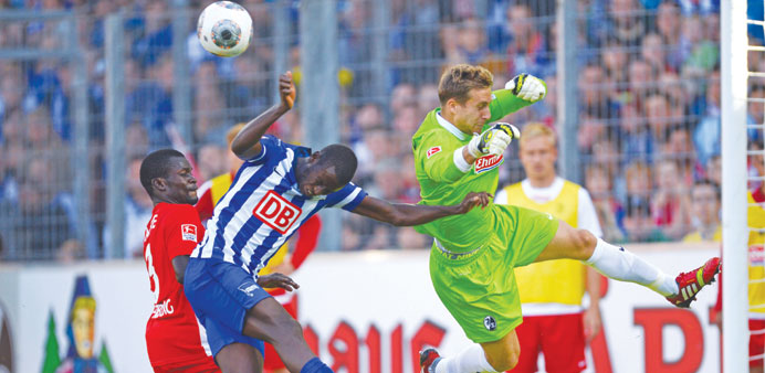 Freiburgu2019s Fallou Diagne (left) and goalkeeper Oliver Baumann (right) vie for the ball with Berlinu2019s Adrian Ramos during the match at Mage Solar Stadi