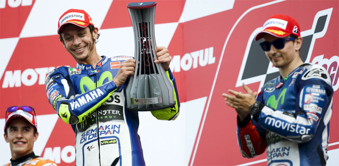 Yamaha MotoGP rider Valentino Rossi of Italy (C) celebrates his victory on the podium with fellow riders Yamaha MotoGP rider Jorge Lorenzo of Spain (R