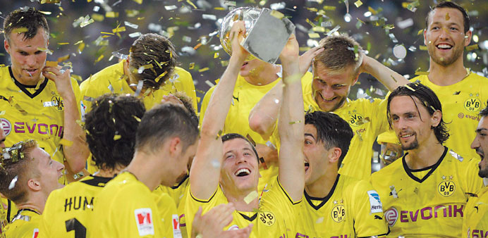 Borussia Dortmundu2019s Robert Lewandowski lifts the Super Cup trophy alongside teammates after beating Bayern Munich in Dortmund on Saturday. (EPA)