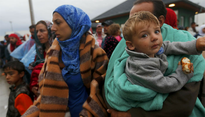 Migrants wait for buses after crossing Austrian border in Nickelsdorf. REUTERS