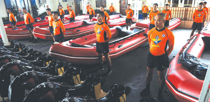 Philippine Coast Guard (PCG) personnel stand in formation beside newly-acquired rubber boats following a blessing ceremony in Manila yesterday.