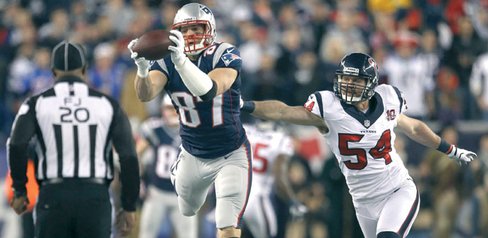 New England Patriotsu2019 Rob Grownkowski (left) reaches for a pass past Houston Texansu2019 Barrett Ruud during the first quarter in their NFL AFC Divisional