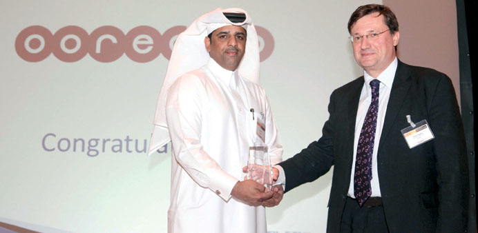 An Ooredoo official receiving the TMT Finance Award.