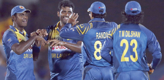 Sri Lankau2019s Thisara Perera (second from left) celebrates taking the wicket of Pakistanu2019s Fawad Alam (not in picture) with captain Angelo Mathews (left