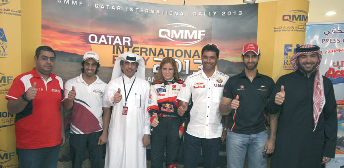 All set: Qatar rallying ace Nasser Saleh al-Attiyah (third from right) poses with fellow drivers yesterday. At right Khalid al-Suwaidi poses with his 