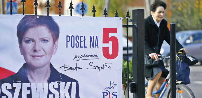 A cyclist rides past an election poster of Law and Justiceu2019s (PiS) candidate Beata Szydlo in Leczyca yesterday morning.