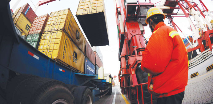 A port worker monitors the unloading of containers on to the trucks at the port of Qingdao in northeast Chinau2019s Shandong province (file). For 2012, Ch