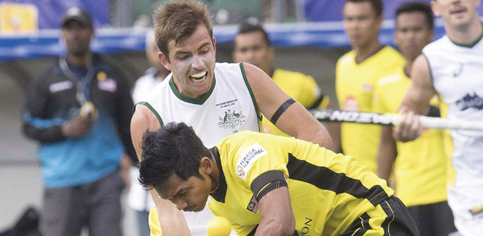 Jacob Whetton (L) of Australia fights for the ball with Razie Abd Rahim of Malaysia during their group match at The Hague in the Netherlands yesterday