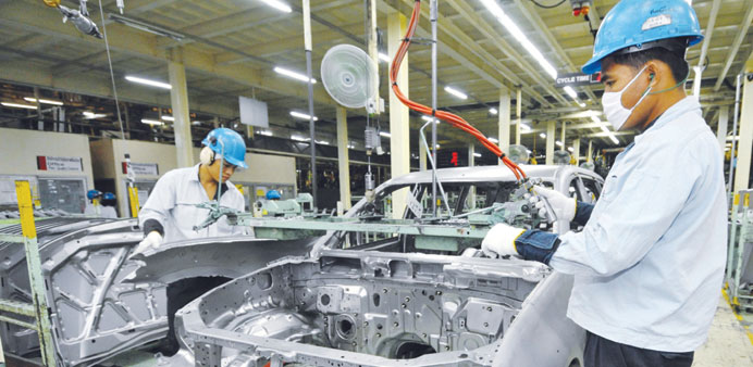 Workers assemble a car at a Mitsubishi Motors plant in Laem Chabang, Thailand. Thai factory output fell nearly twice as much as expected in June.