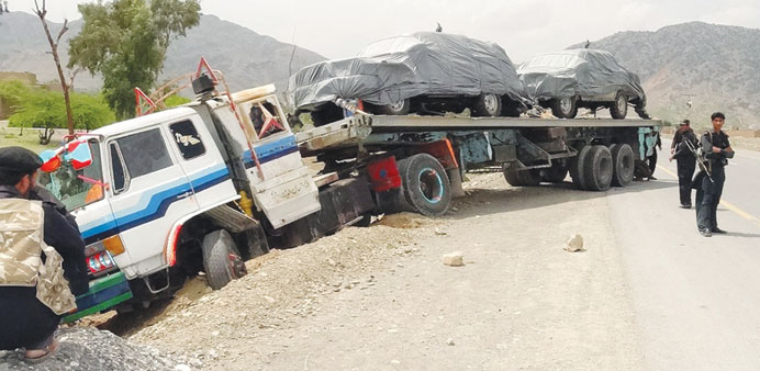 Pakistani security officials inspect the site where unknown gunmen opened fire on a truck carrying logistics supplies for Nato forces in Afghanistan, 