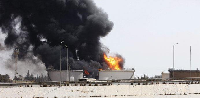 Smoke billows from a fire at a fuel depot near the airport road in Tripoli yesterday.