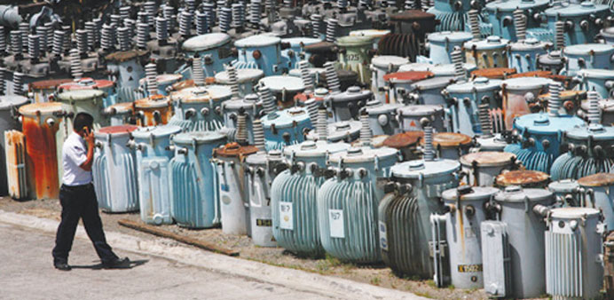 A security guard inspects old transformers at a stockyard of the Manila Electric Co (Meralco) in Quezon City yesterday.
