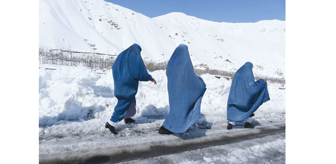 Afghan women make their way near an avalanche site at Dara Keraman district of Panjshir province, north of Kabul, yesterday.