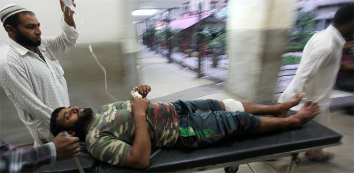 An injured villager is transported by medical staff at a hospital in Jammu after he was injured in cross-border firing in Indian-administered Kashmir 